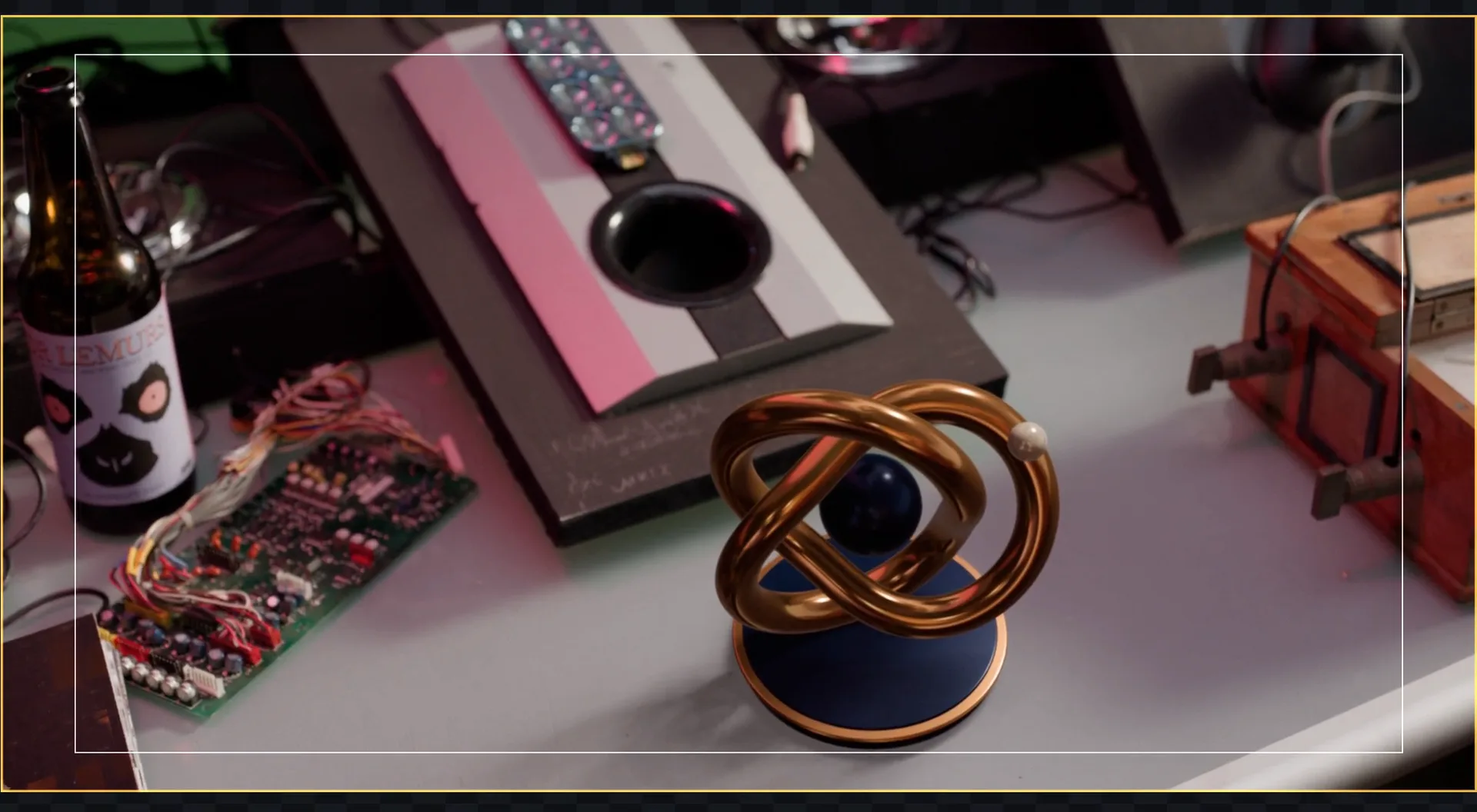 A gold 3D knot standing on a cluttered desk from Tears of Steel, placed by a camera solved with BATIQ's Camera Tracker and live-linked to a 3D Set
